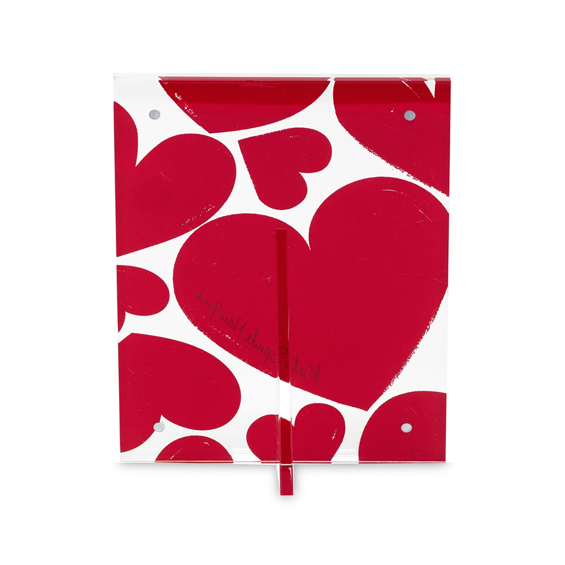 Backview of red heart-patterned picture frame with 'kate spade new york' branding on a white background