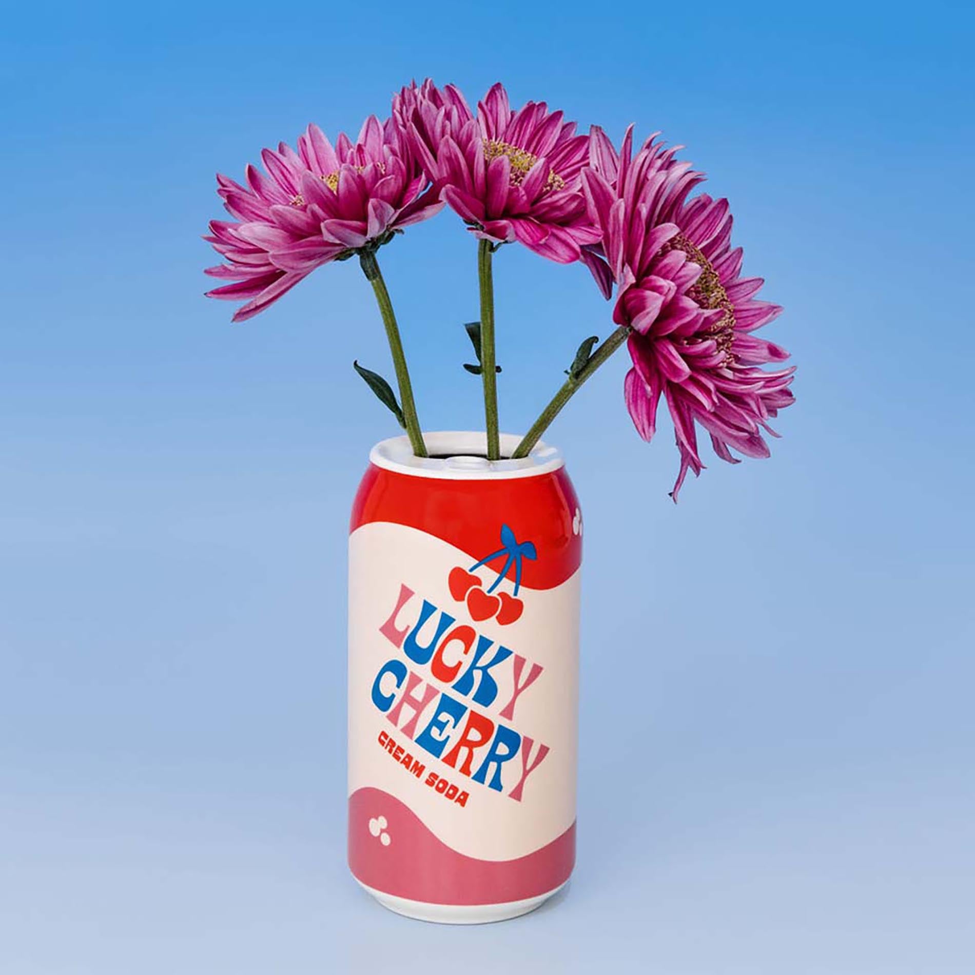 Red and white can-shaped vase with 'Lucky Cherry' branding holding pink flowers against a blue background