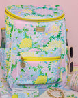 Floral-patterned cooler bag with sunglasses and a bottle on a pink background