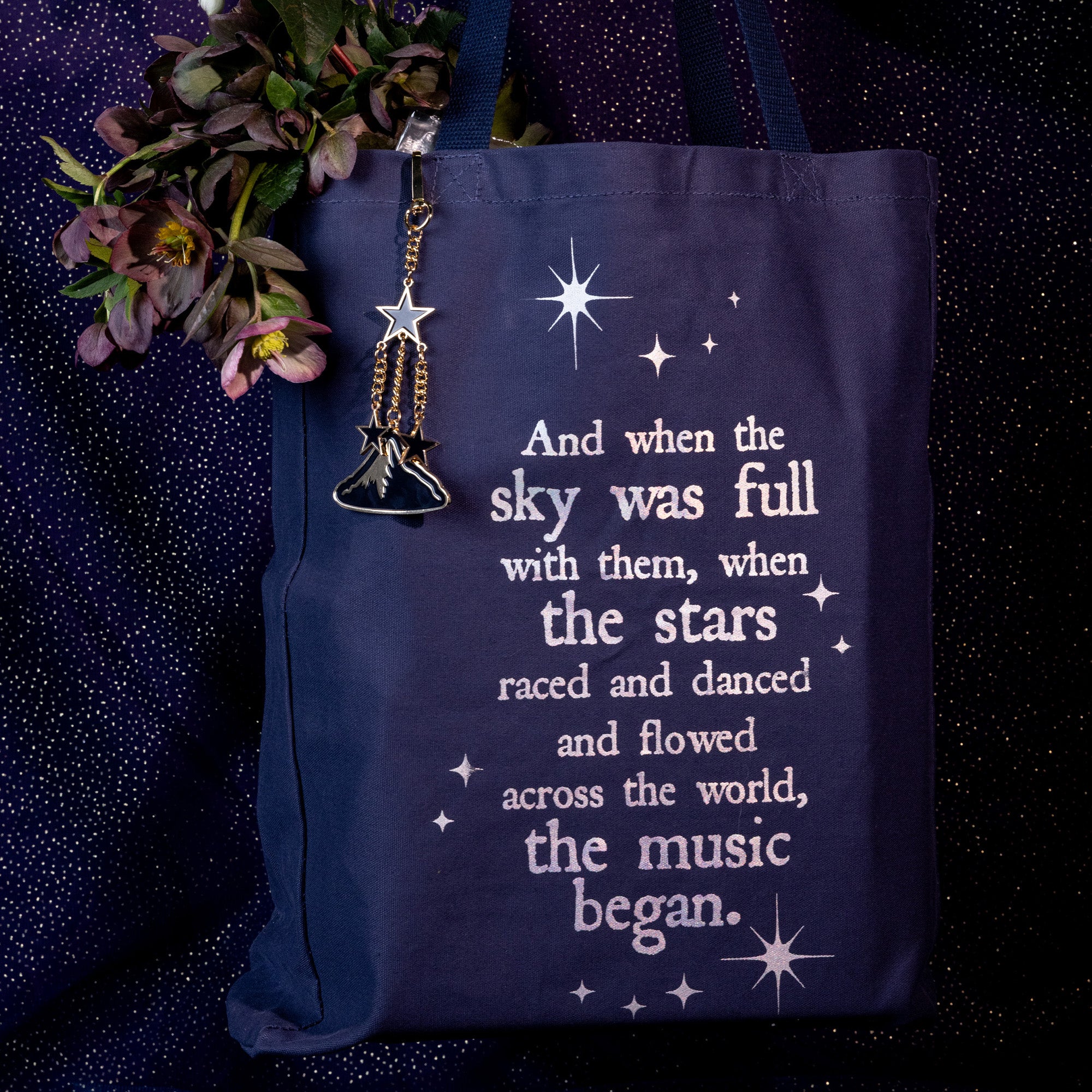 Keychain with mountain and star charms  on a navy tote
