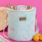 Small cylindrical handbag with floral pattern and gold accents on a white background
