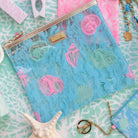 blue pouch with colorful seashell print on a blue beach towel