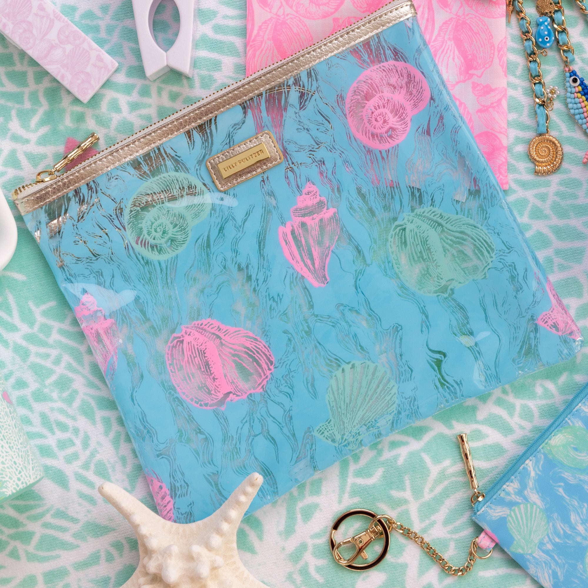 blue pouch with colorful seashell print on a blue beach towel
