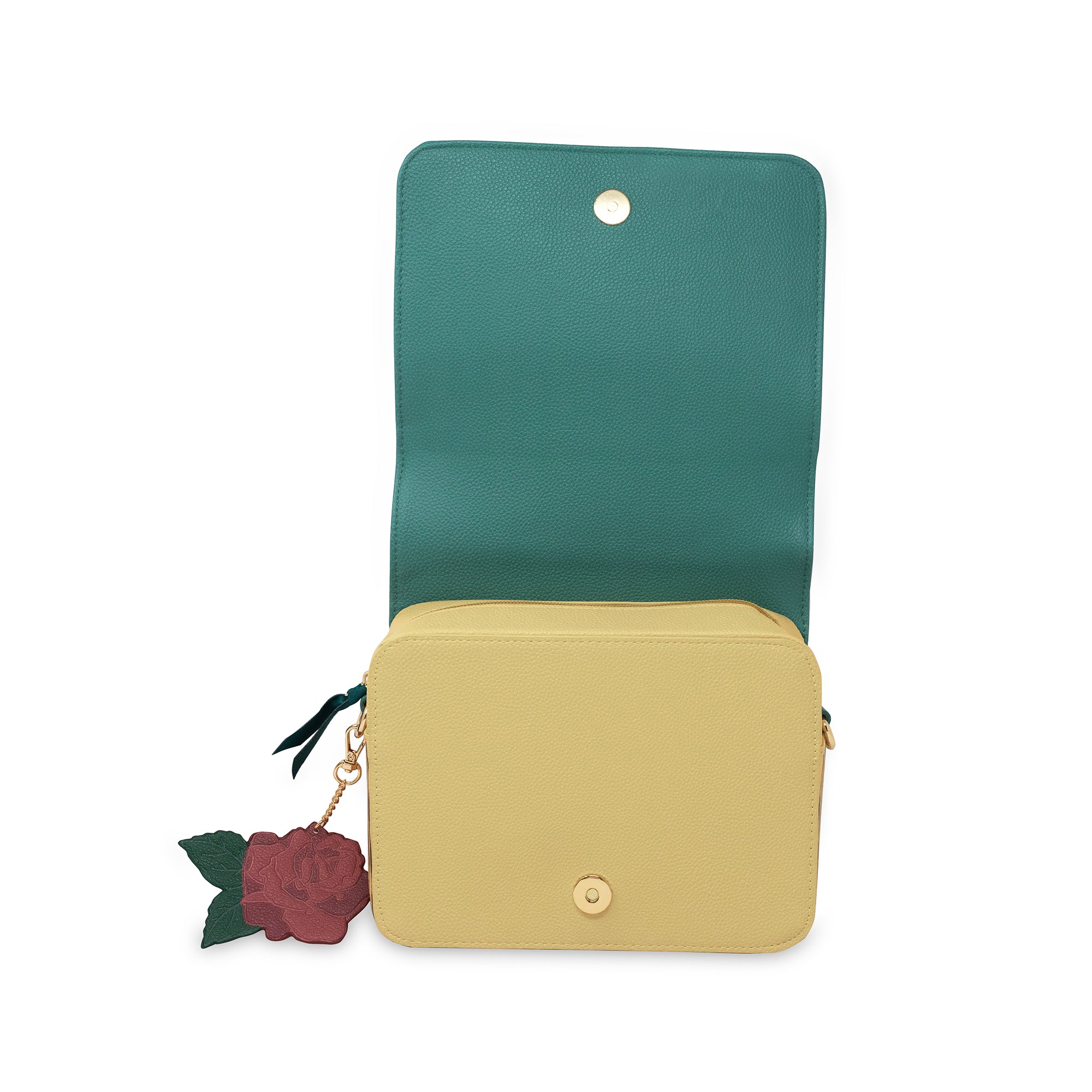 Green and beige crossbody bag with a decorative rose charm on a white background