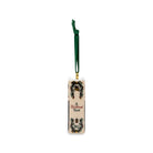 A Christmas ornament with a dark green hanging ribbon, featuring 'A Christmas Carol' text and decorative illustrations on a white background.