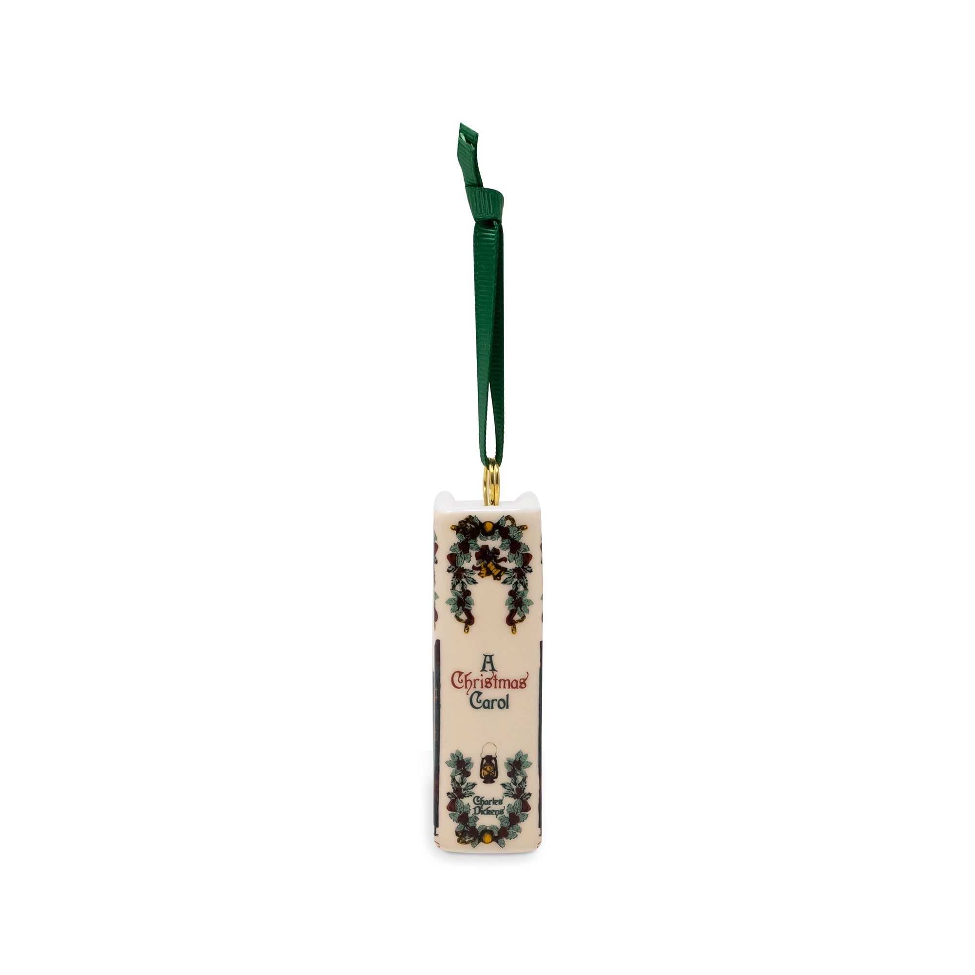A Christmas ornament with a dark green hanging ribbon, featuring 'A Christmas Carol' text and decorative illustrations on a white background.