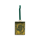 A square Christmas ornament featuring a dark green background with intricate gold floral and leaf patterns, a small gold hanging ring, and a dark green hanging ribbon at the top.