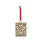 A rectangular Christmas ornament with a red hanging ribbon and gold loop, featuring the text 'Twelve Days of Christmas' in dark green lettering on a beige background with decorative green foliage and small holiday illustrations.