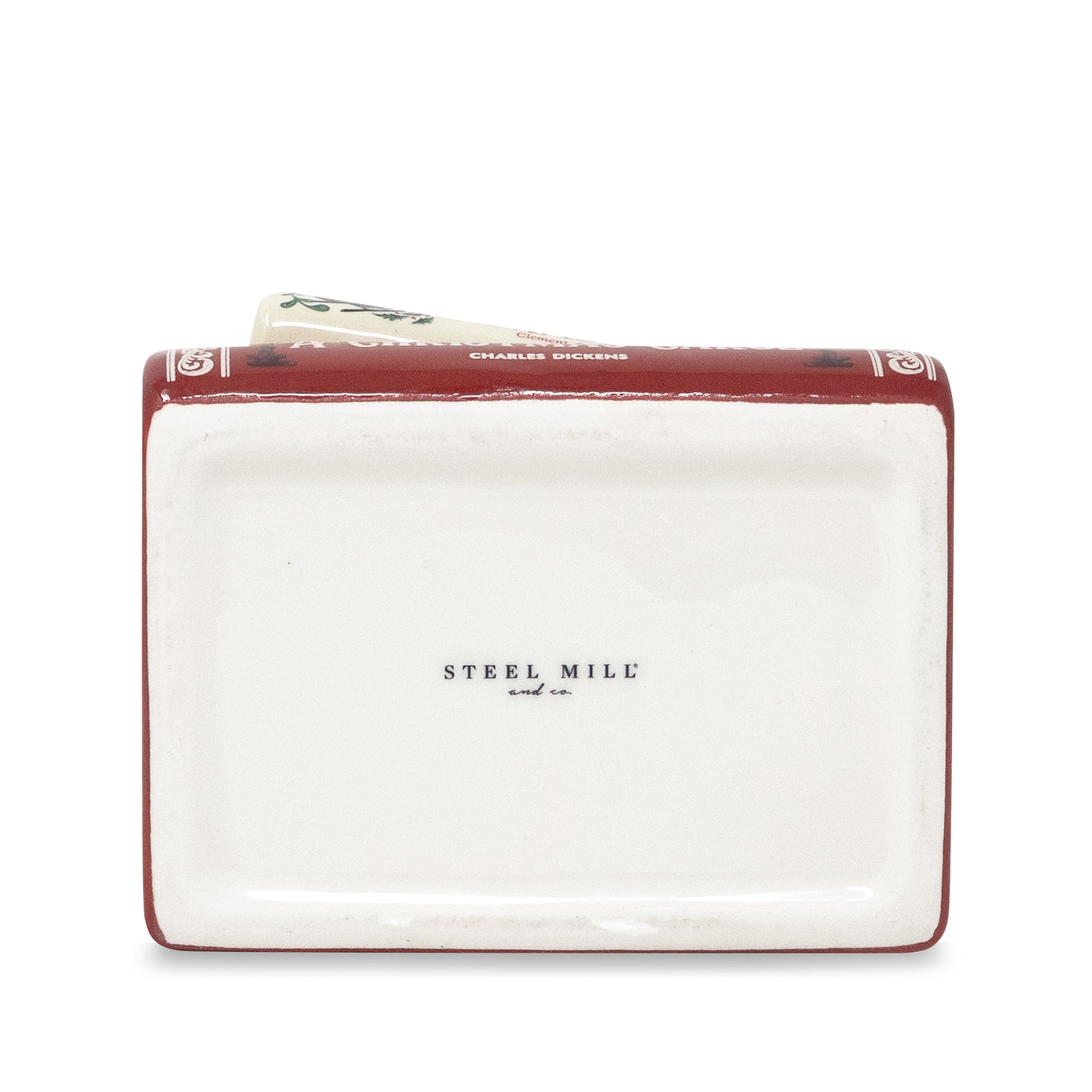 A rectangular ceramic money box designed to look like a vintage book, featuring a white cover with 'STEEL MILL and Co.' printed in black, and a dark red spine with gold decorative details.