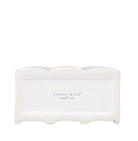 A white ceramic napkin holder with a scalloped rim and the brand name 'STEEL MILL and co.' printed in blue on the front, set against a plain white background.