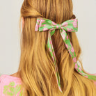 model wearing green hair bow with pink flowers