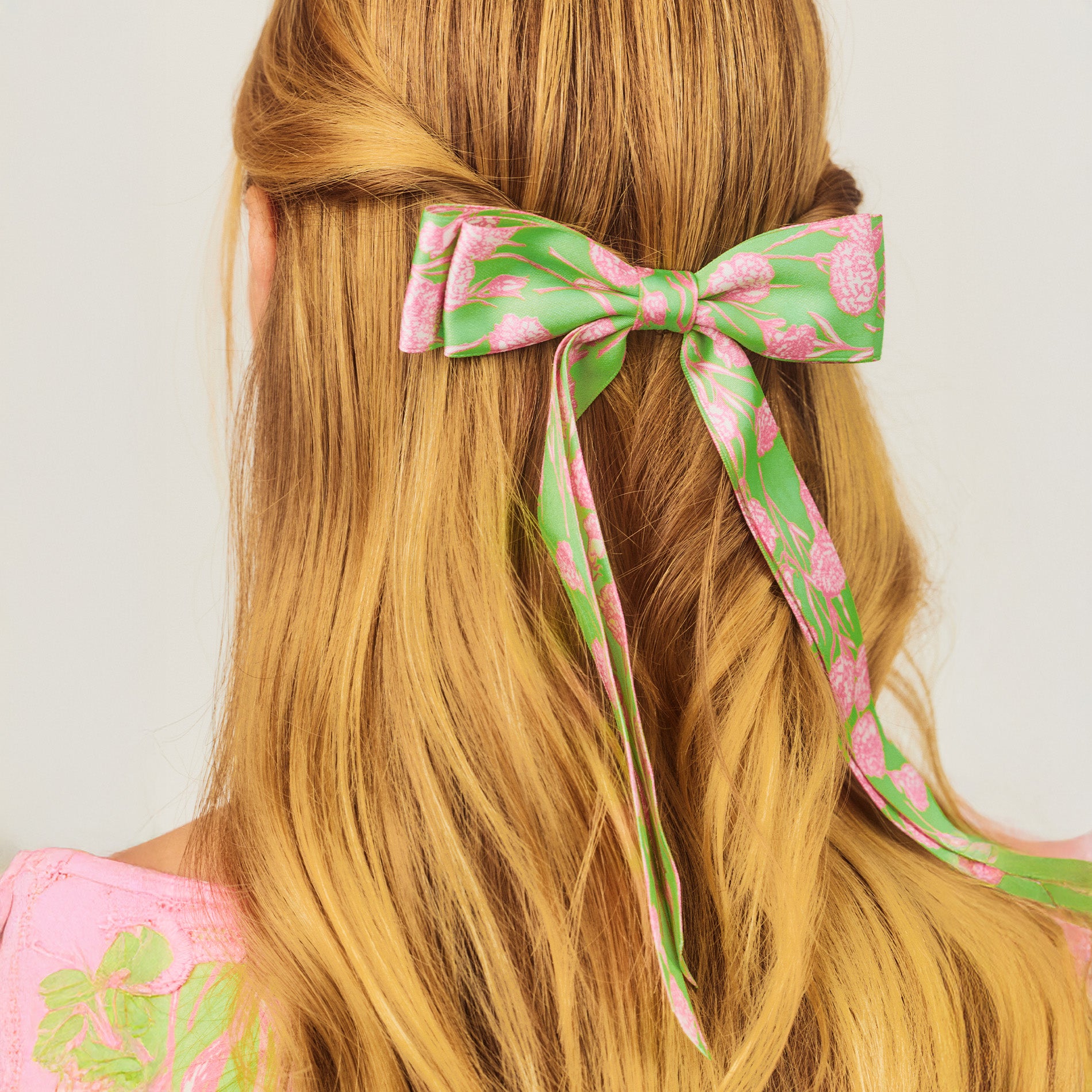 model wearing green hair bow with pink flowers