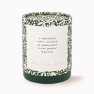 A cylindrical scented candle in a dark green jar with a white label reading 'A GARLAND OF GREEN GALBANUM IN CHORUS WITH CLOVE, JASMINE & BALSAM' and 'Fabulously Festive' in gold script. The lid and sides feature a green botanical pattern with small pink and white floral accents, set against a clean white background.