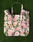 Floral patterned tote bag on a green textured background