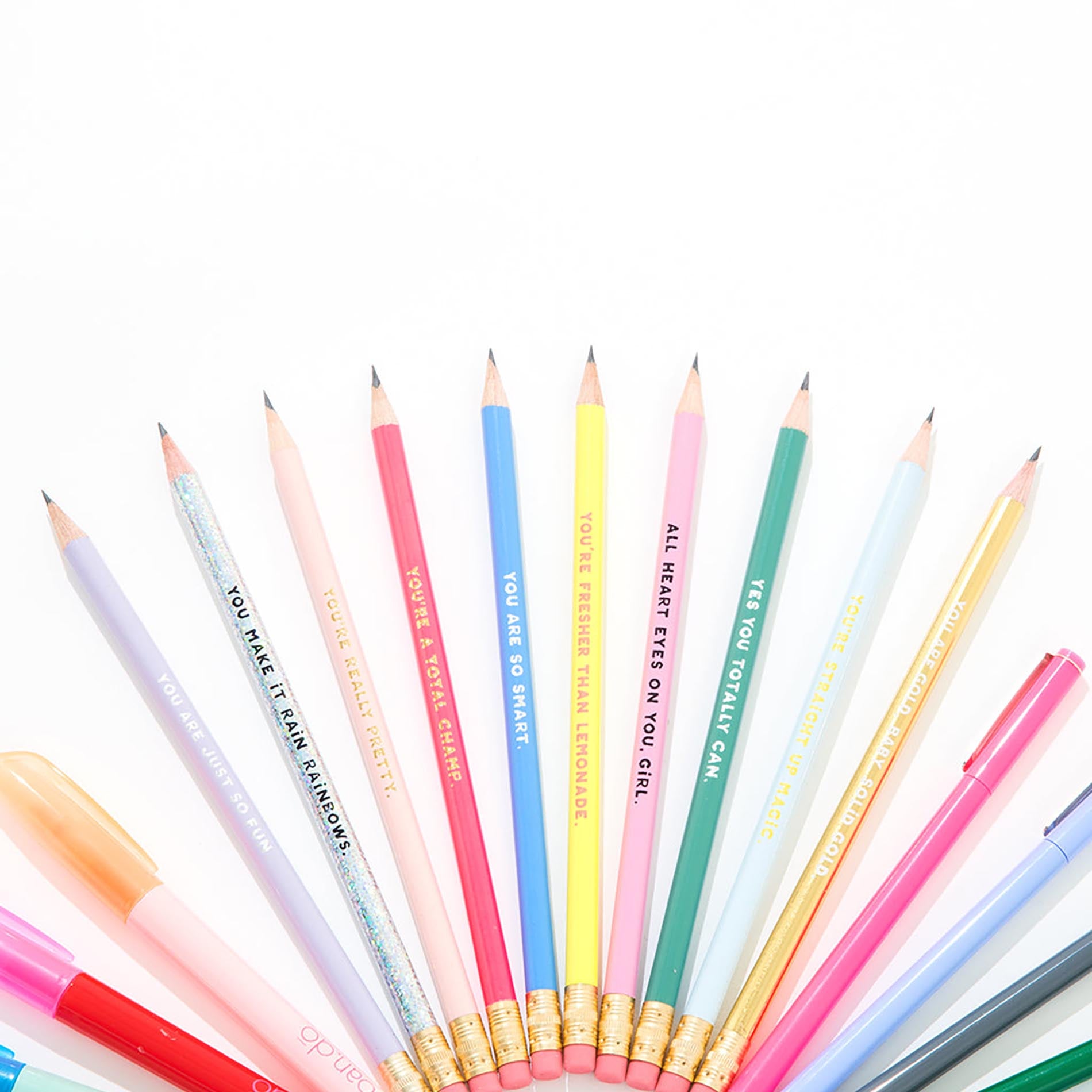 Assorted colored pencils with motivational text on a white background
