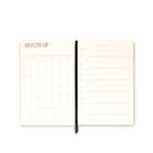 An open monthly planner spread on a clean white background, showing blank calendar and task-tracking pages with a black ribbon bookmark.