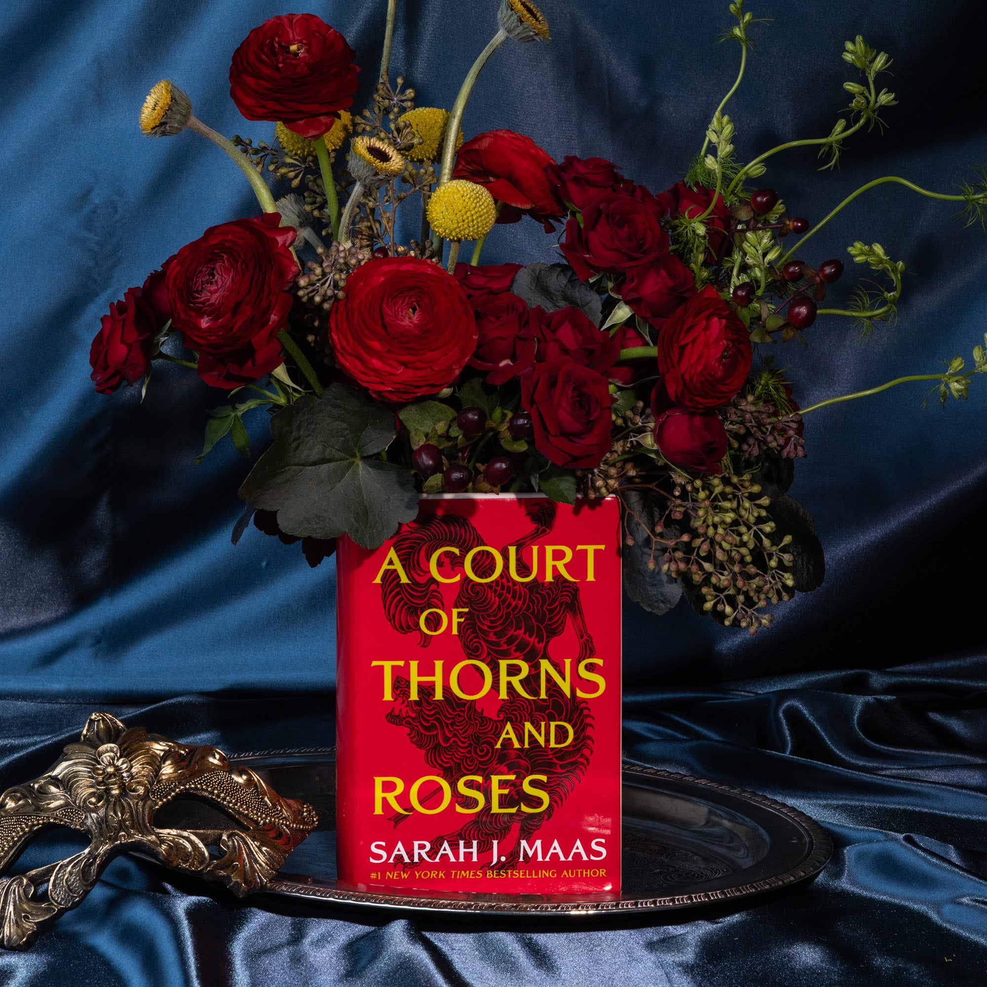 Book-shaped vase with 'A Court of Thorns and Roses' design with  bouquet inside