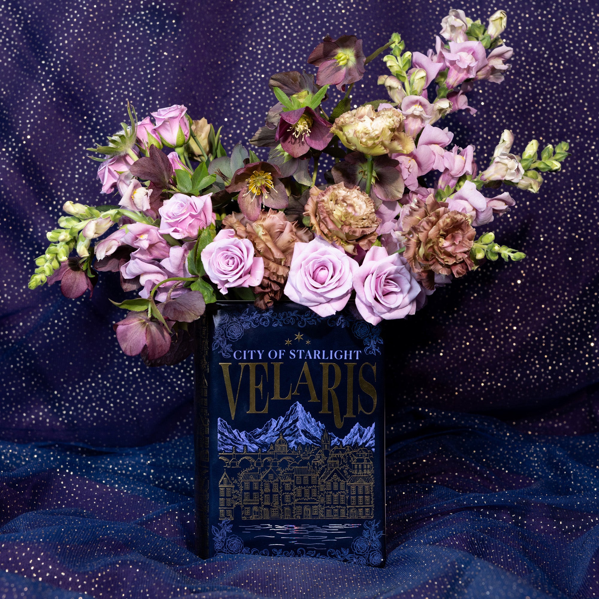 Book-shaped vase with 'Velaris' design with a bouquet inside