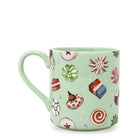 A light green ceramic mug decorated with a whimsical pattern of various sweets, candies, and flowers, shown against a plain white background.