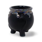 Black ceramic pot with colorful interior on a white background