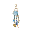 Decorative keychain with blue fish charm on a white background