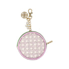 A small round coin purse with a light pink and white geometric pattern, a light green trim, and gold-tone hardware including a clasp, charm, and zipper pull.