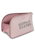 Pink toiletry bag with 'KEEPING IT TOGETHER' text on a white background