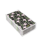 A clear plastic card storage box containing paper napkins with a black background, pink flowers, and green vines.