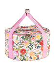 Floral-patterned dutch over carrier with pink handle on a white background