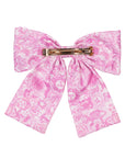 Pink floral bow hair clip on a white background