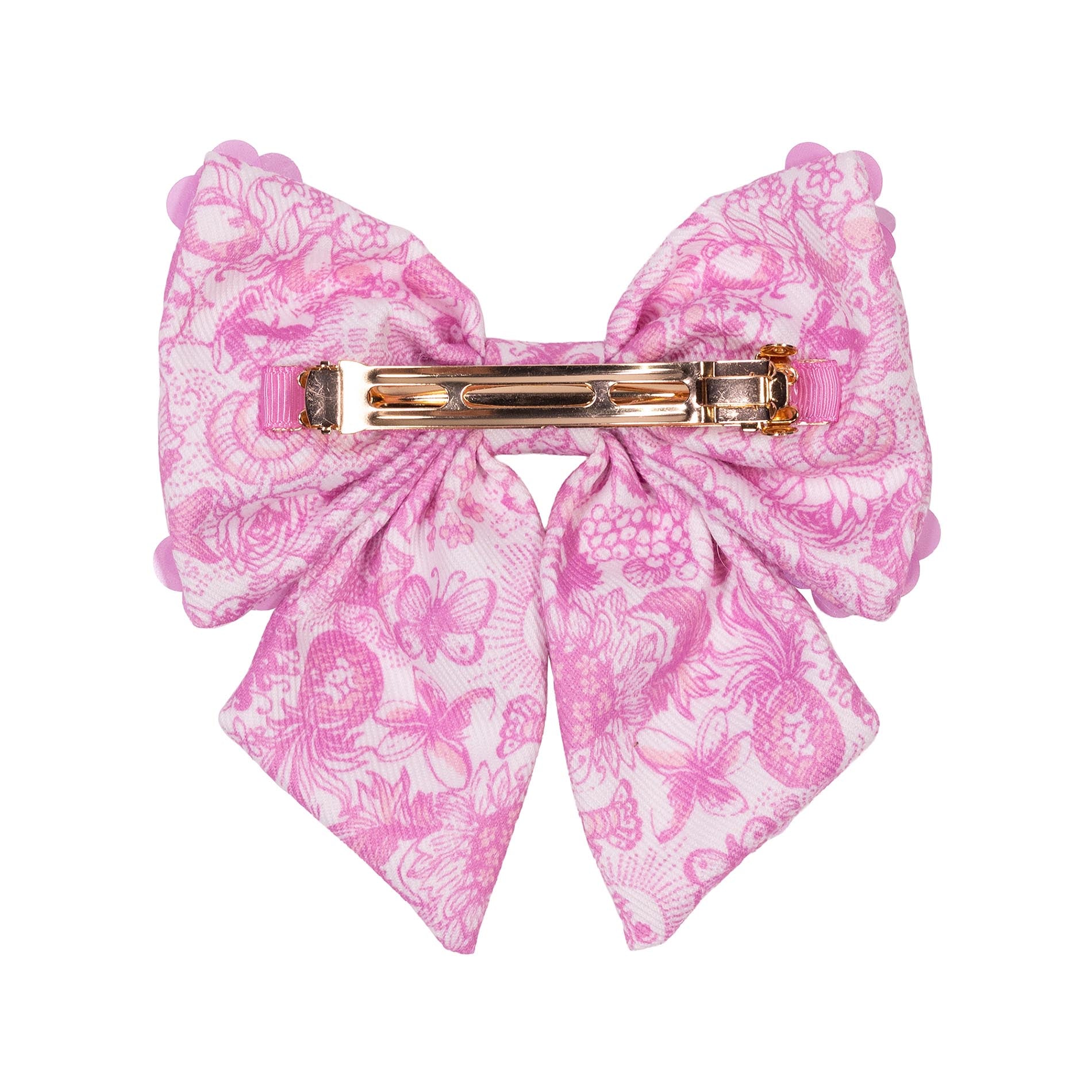 Pink floral bow with a gold clip on a white background