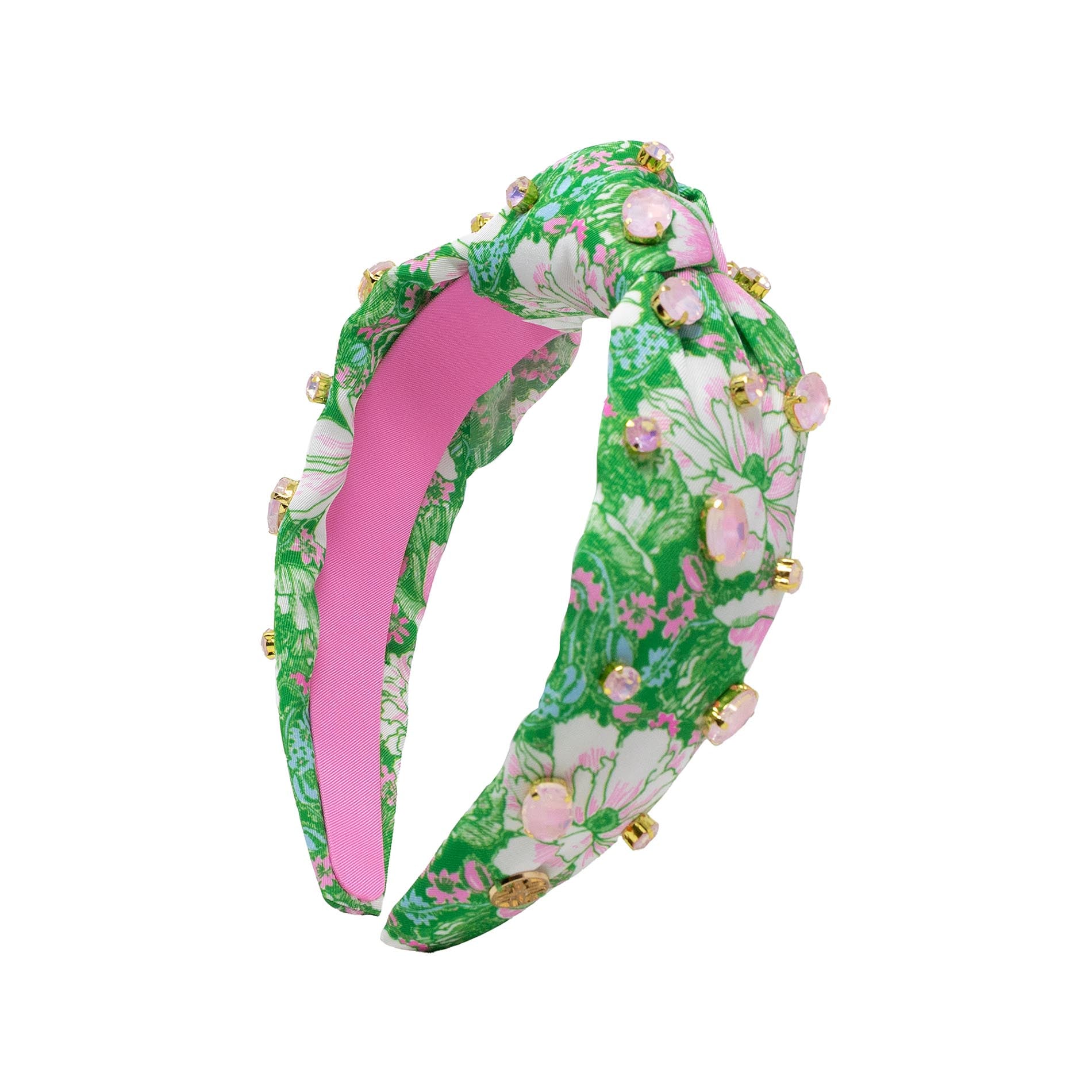Floral headband with pink center and green leaves on a white background