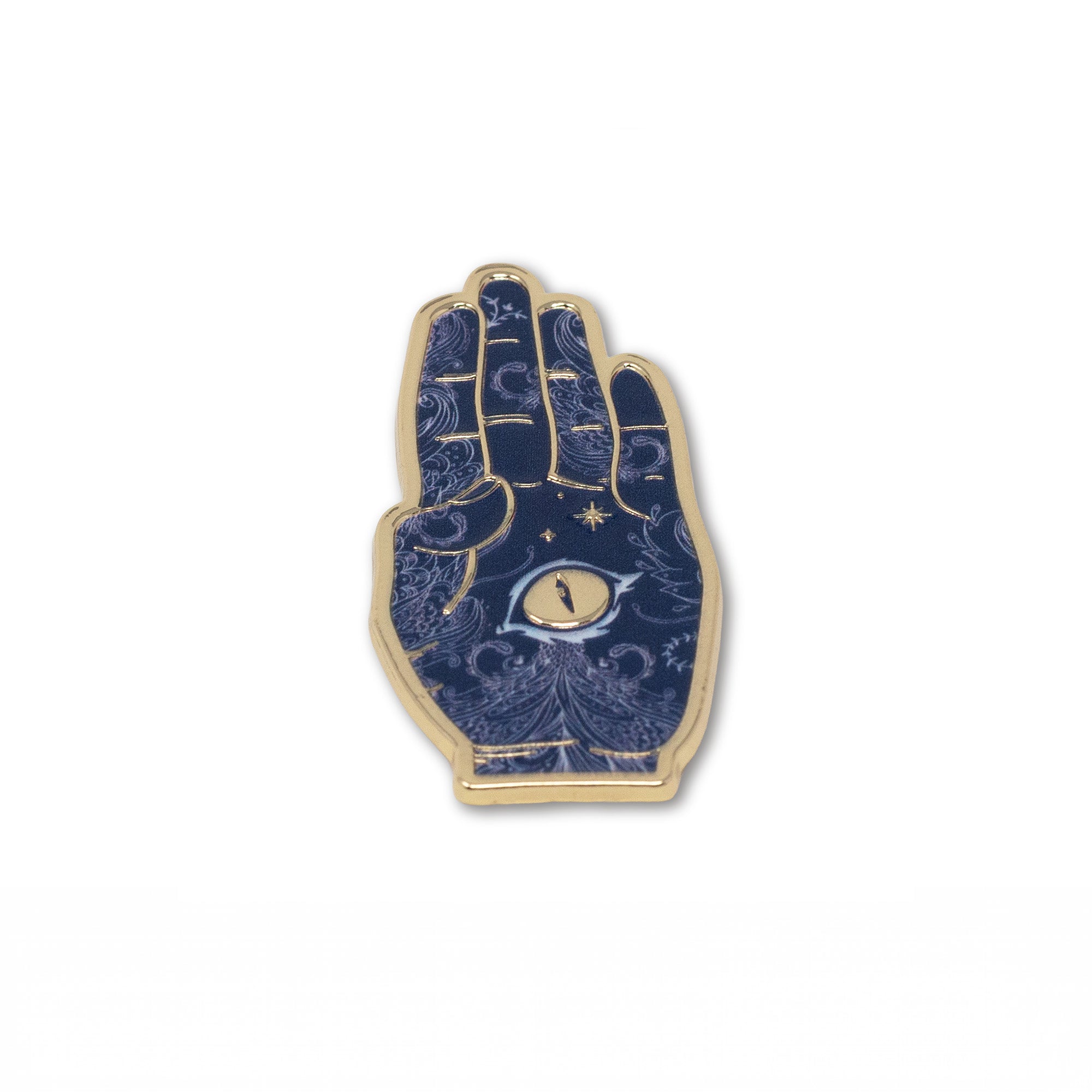 A hand enamel pin with a gold-tone metal border and a dark blue background decorated with gold celestial patterns, stars, and a central eye motif.