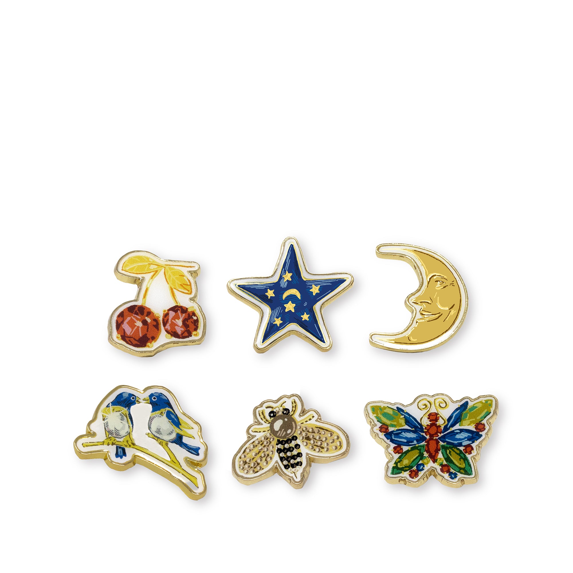 Six small enamel pin designs arranged on a white background: cherries, a blue star with gold stars and a crescent moon, a smiling crescent moon, two blue birds, a bee, and a colorful butterfly.