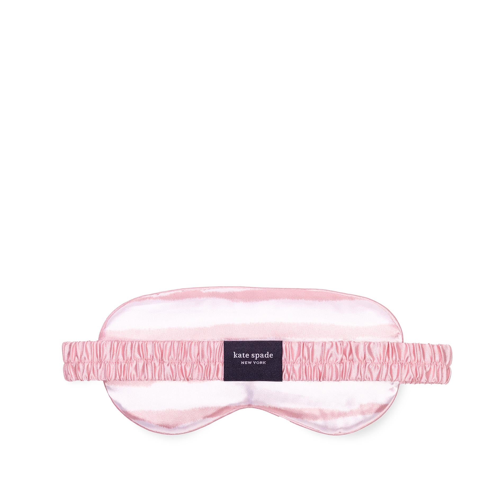 Pink sleep mask with 'kate spade' label on a white background