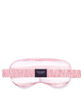 Pink sleep mask with 'kate spade' label on a white background