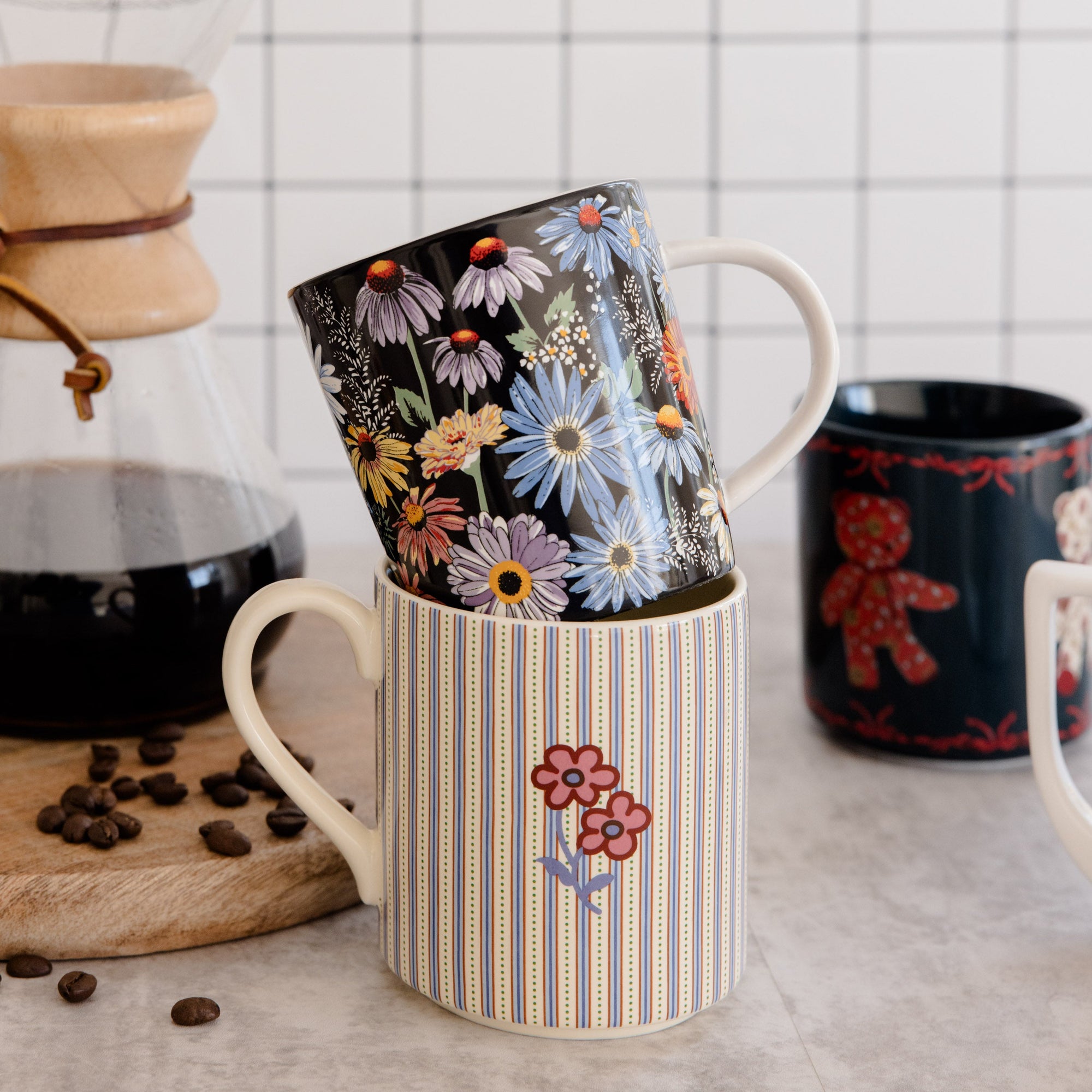 Colorful mugs with floral designs on a kitchen counter.