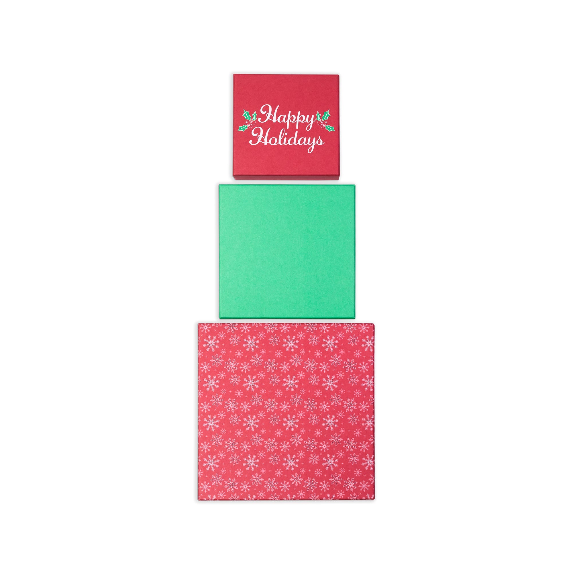 Three stacked square holiday-themed paper sheets on a white background: a red top sheet with 'Happy Holidays' in white script and small green/red floral accents, a plain green middle sheet, and a red bottom sheet with a white snowflake pattern.