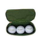 Three golf balls with 'kate spade new york' branding in a green case.