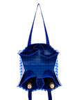 Blue tote bag with checkered lining holding two bottles on a white background