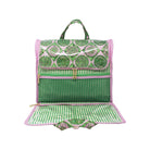 A green and pink patterned backpack shown open, revealing a zippered compartment, striped interior lining, and a matching handle, photographed on a plain white background.