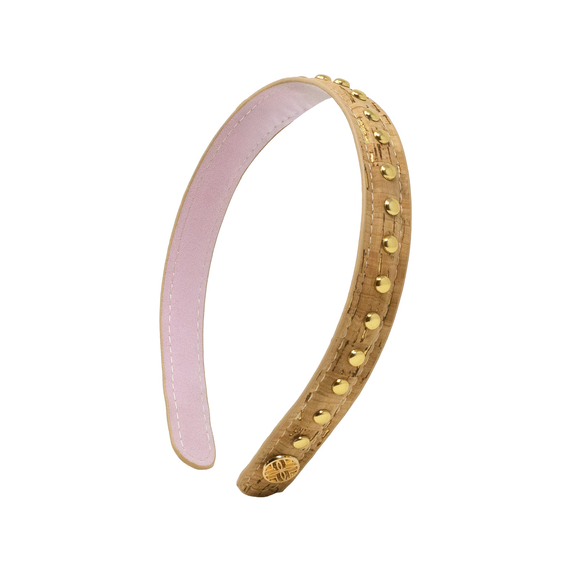A curved tan leather headband decorated with gold-tone studs and a small gold medallion, featuring a light pink interior lining, shown on a plain white background.