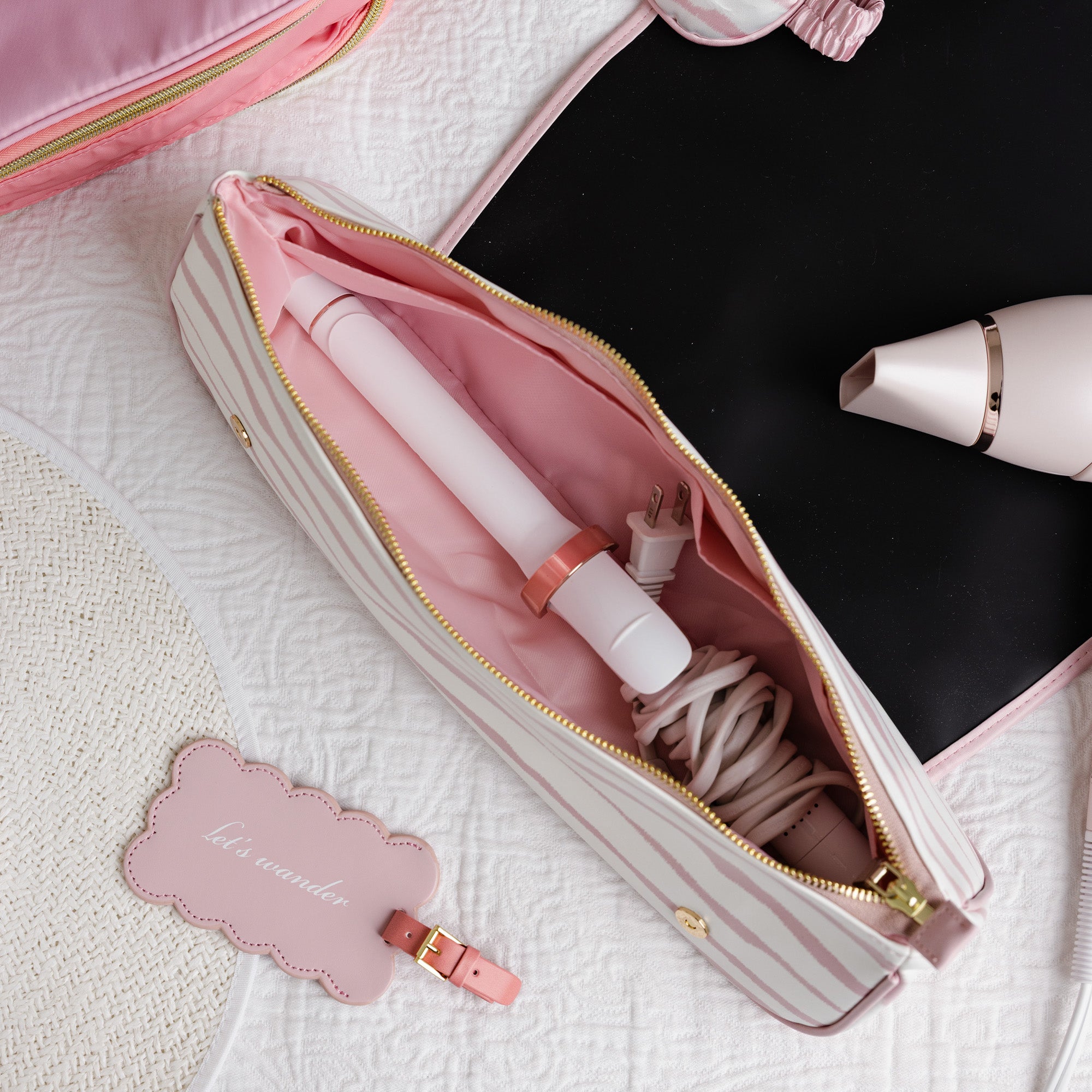 Pink hair straightener in a pink case with a matching tag on a textured surface