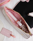 Pink hair straightener in a pink case with a matching tag on a textured surface