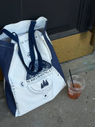 suriel trading co tote bag with a beverage next to it