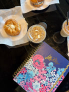 Floral notebook with 'Lilly Pulitzer' branding surrounded by baked goods