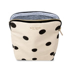 A Kate Spade New York cosmetic pouch in cream canvas with black polka dots, featuring a gold zipper and the brand's name printed in gold on the front.