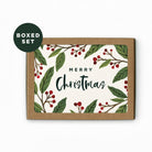 packaged Christmas card with green leaves and red berries and a brown envelope with 'Merry Christmas' on a white background