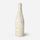 Decorative tissue paper with gold floral pattern wrapped around a bottle