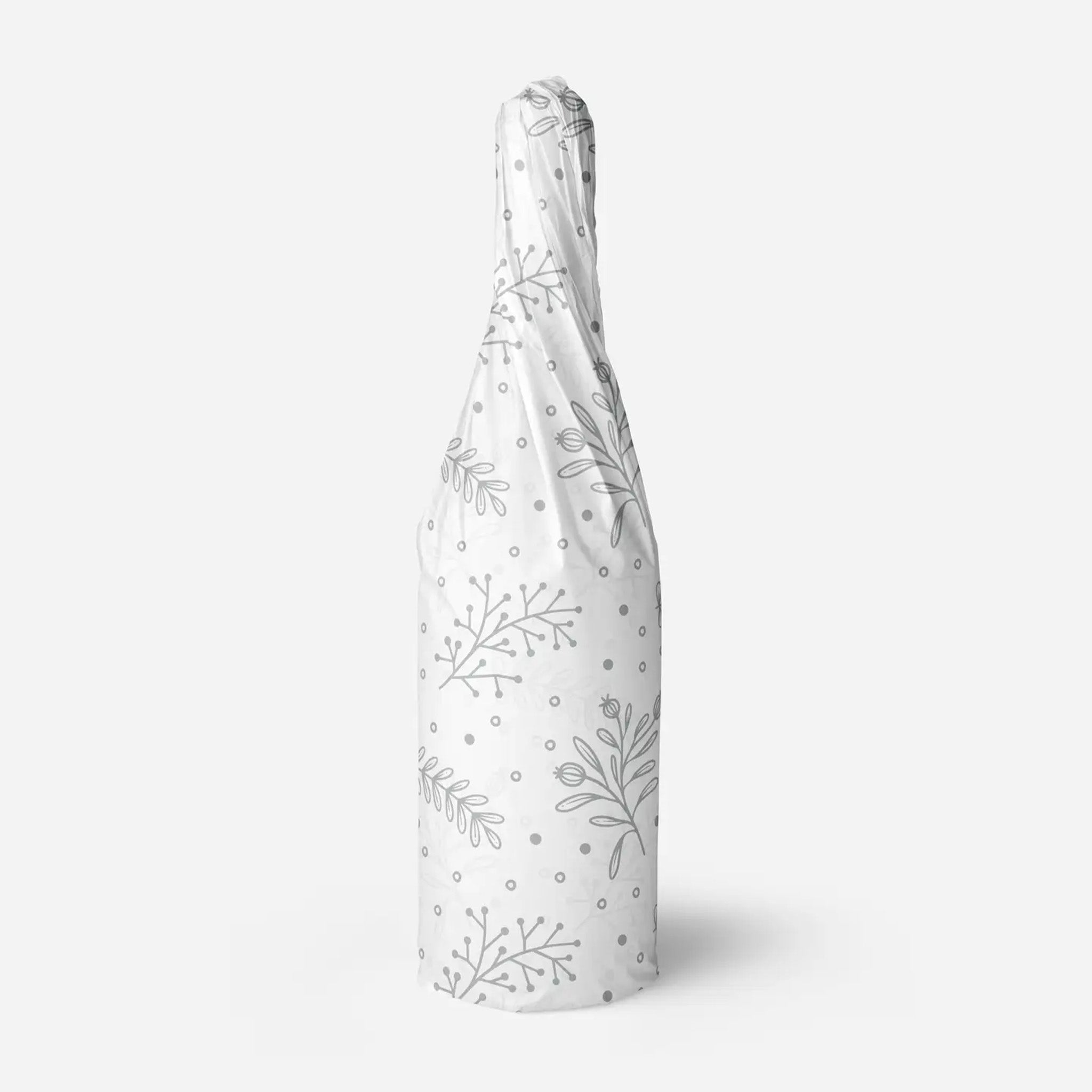 Silver floral patterned tissue paper wrapped around a bottle